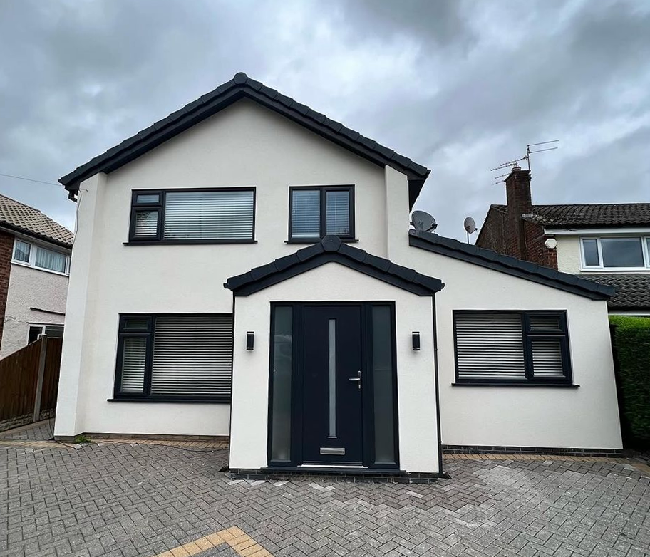 Front elevation of a completed white-rendered detached house with new anthracite door and roof by Ultra Build Northwest