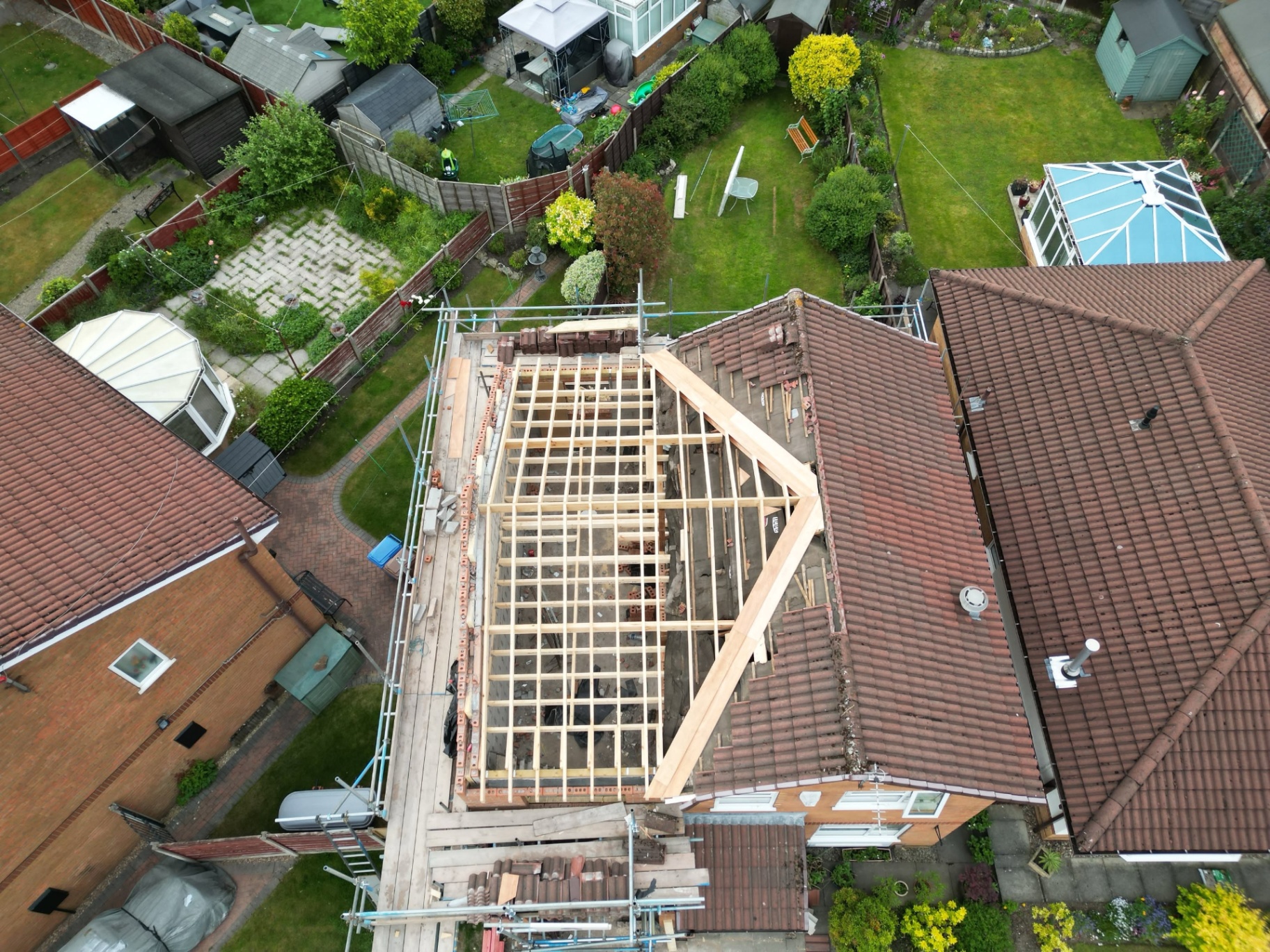 Aerial view of loft conversion in progress with new timber roof trusses over existing house