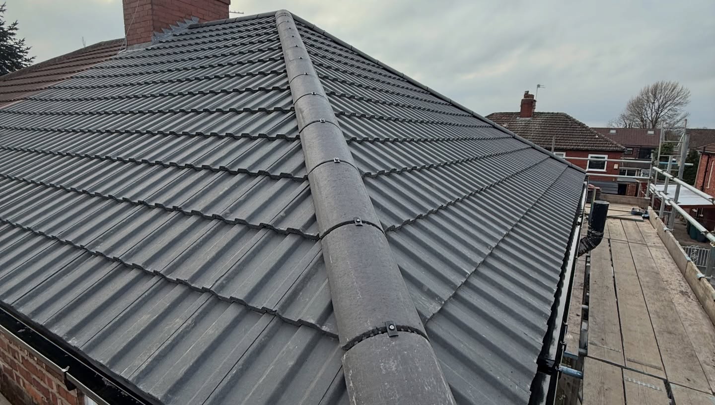 Close-up of new slate-grey tiled pitched roof and ridge by Ultra Build Northwest, Greater Manchester